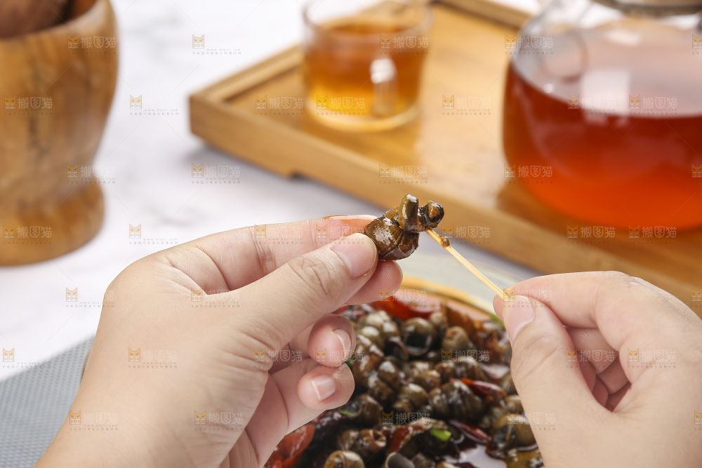 手里拿着牙签挑田螺肉