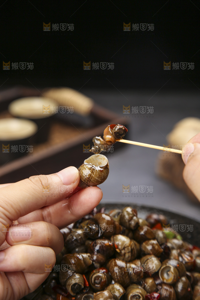 手里拿着牙签挑田螺肉