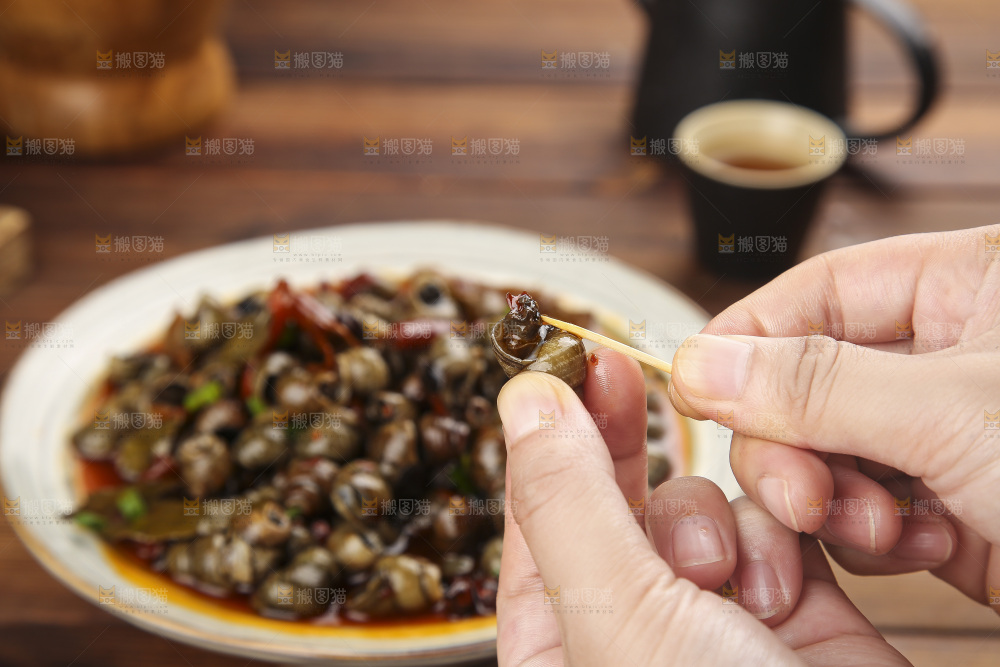 手里拿着牙签挑田螺肉
