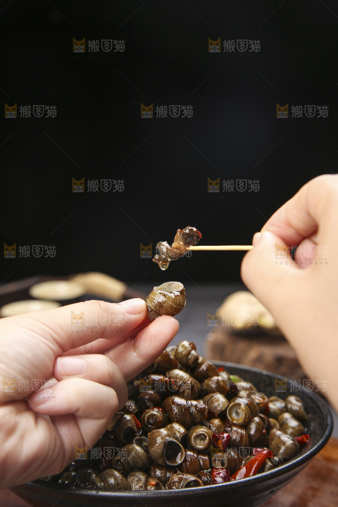 手里拿着牙签挑田螺肉