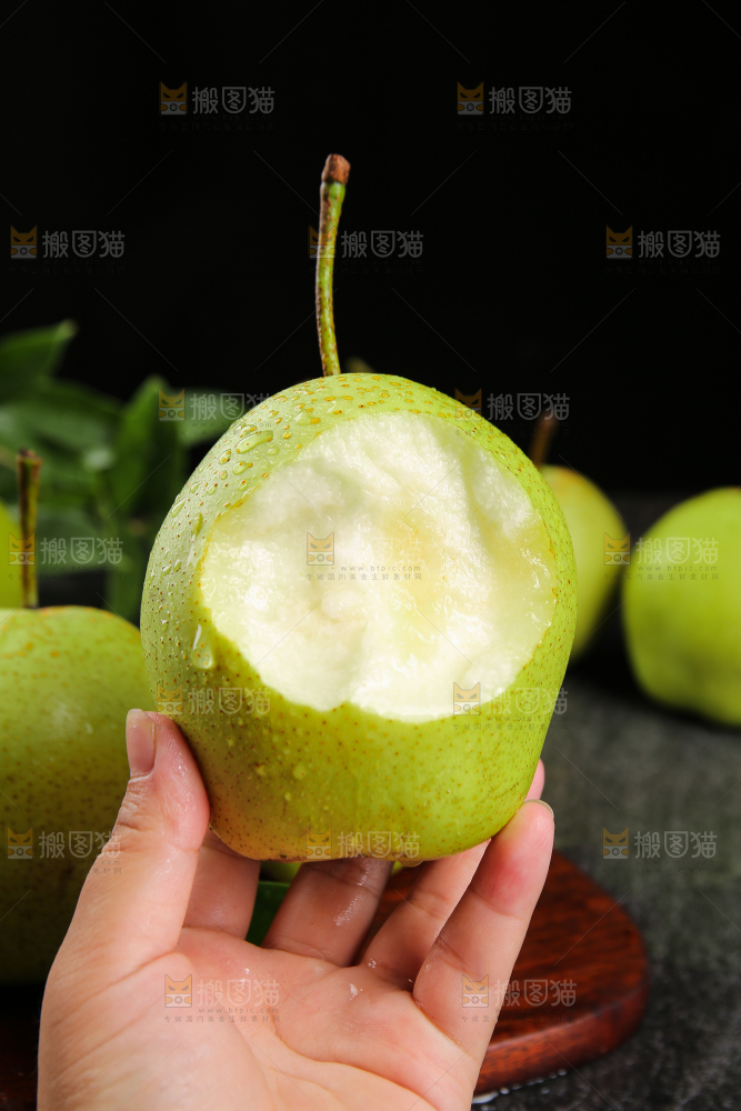 手里拿着咬开的新鲜早酥梨