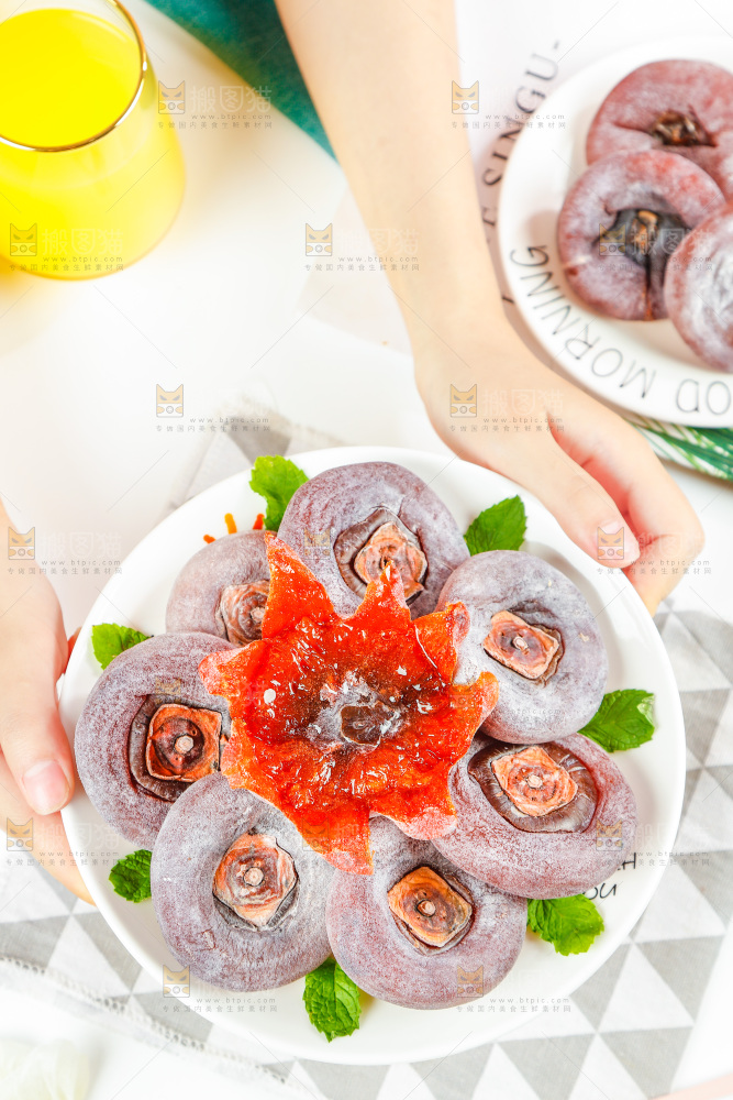 手端着一盘流心柿饼