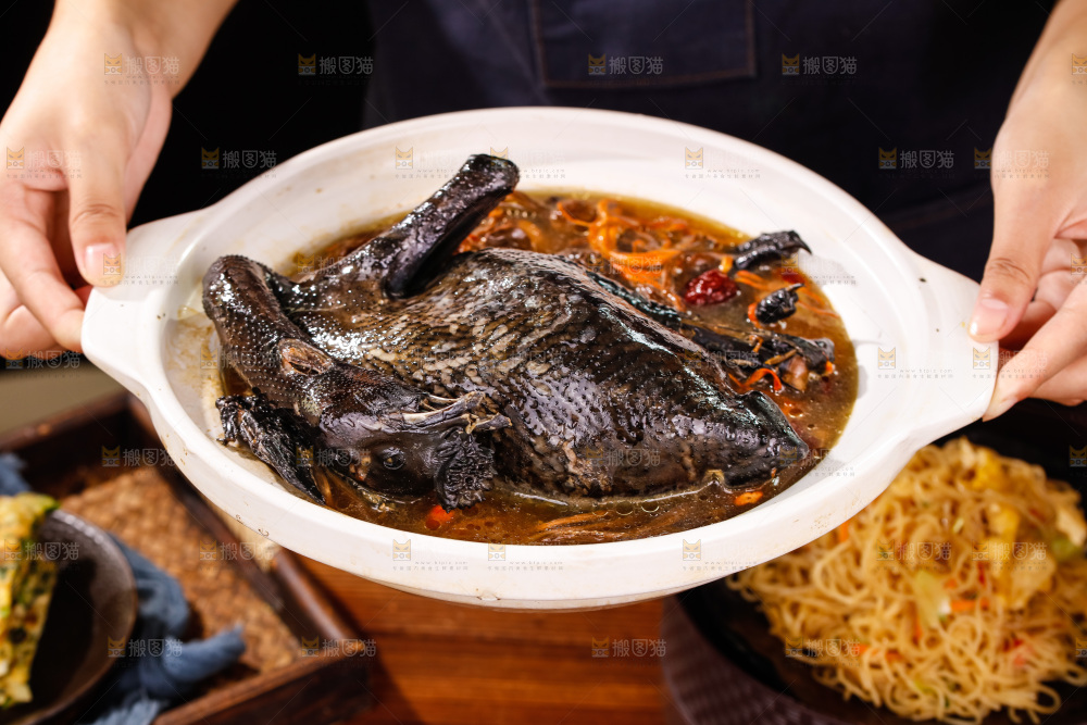 手里端着一锅茶树菇乌鸡汤