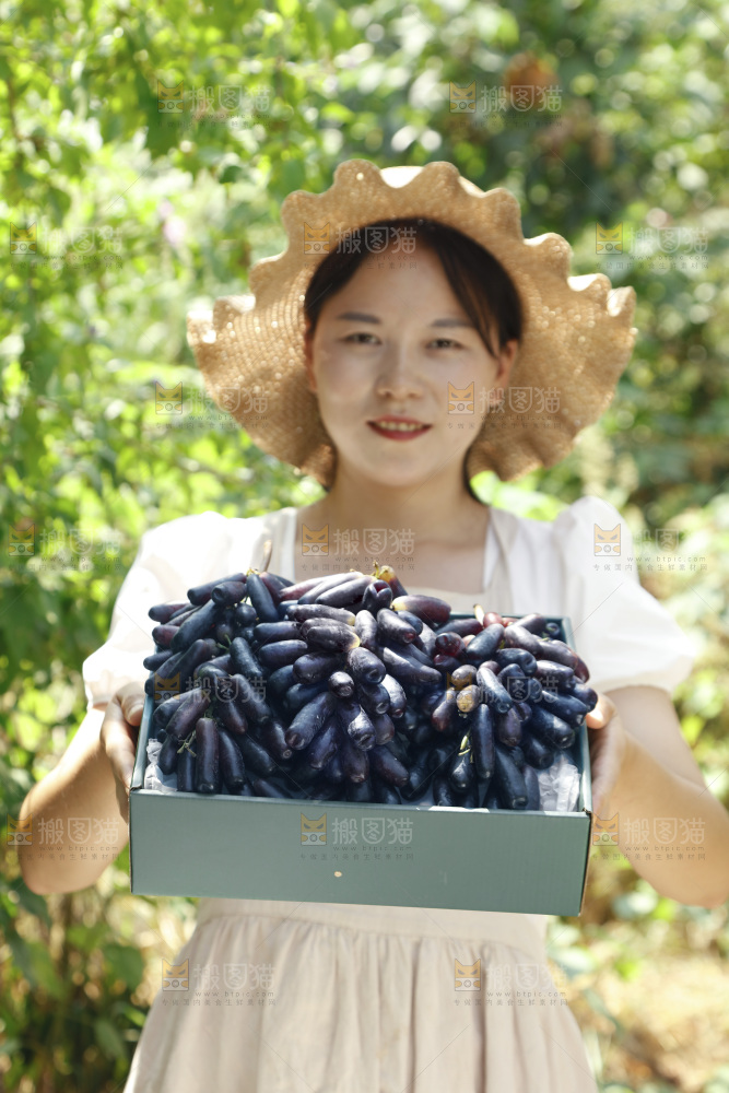 女孩拿着一盒蓝宝石葡萄
