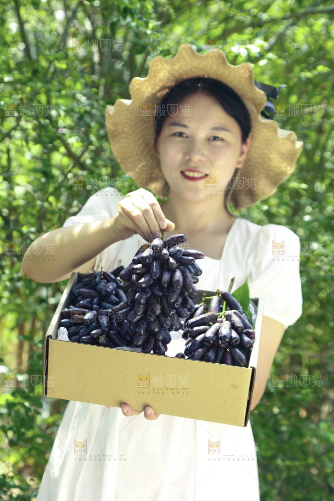 女孩拿着一盒蓝宝石葡萄