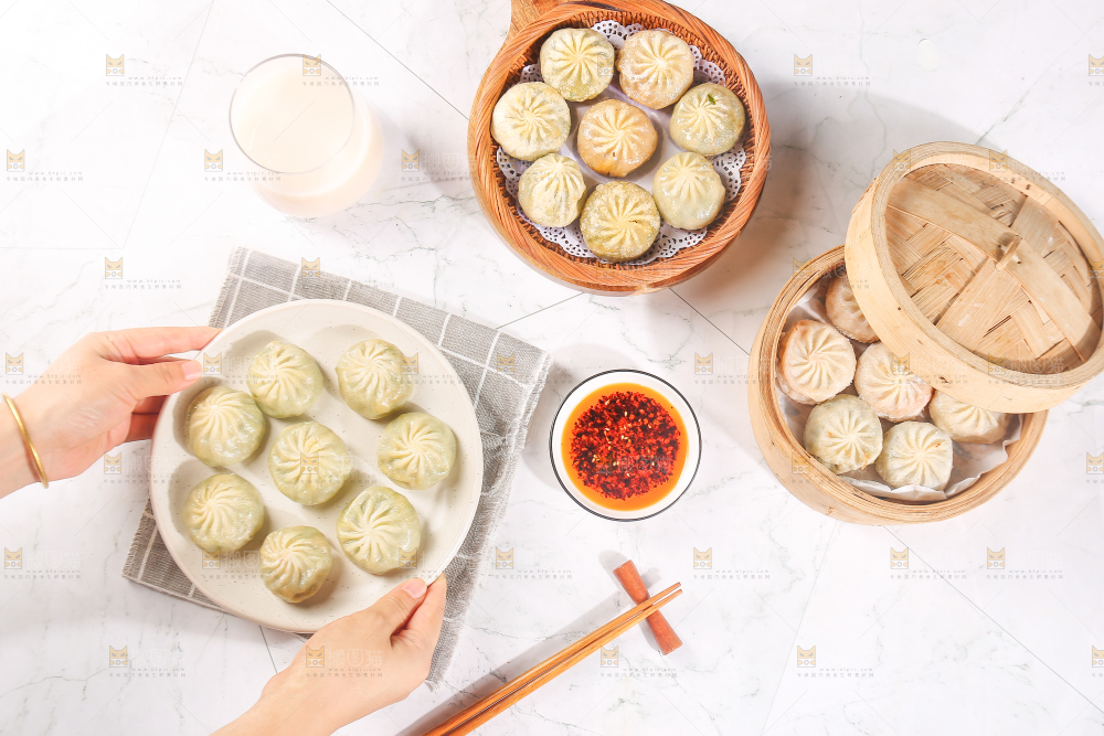 手端着一盘小包子