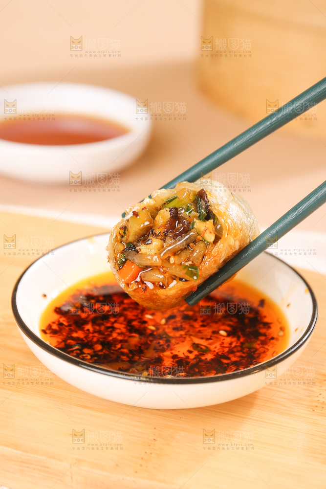 筷子上夹着蘸酱的包子