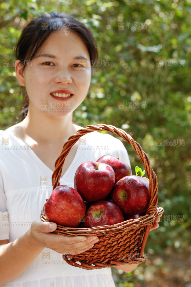 女孩手里拿着一篮花牛苹果