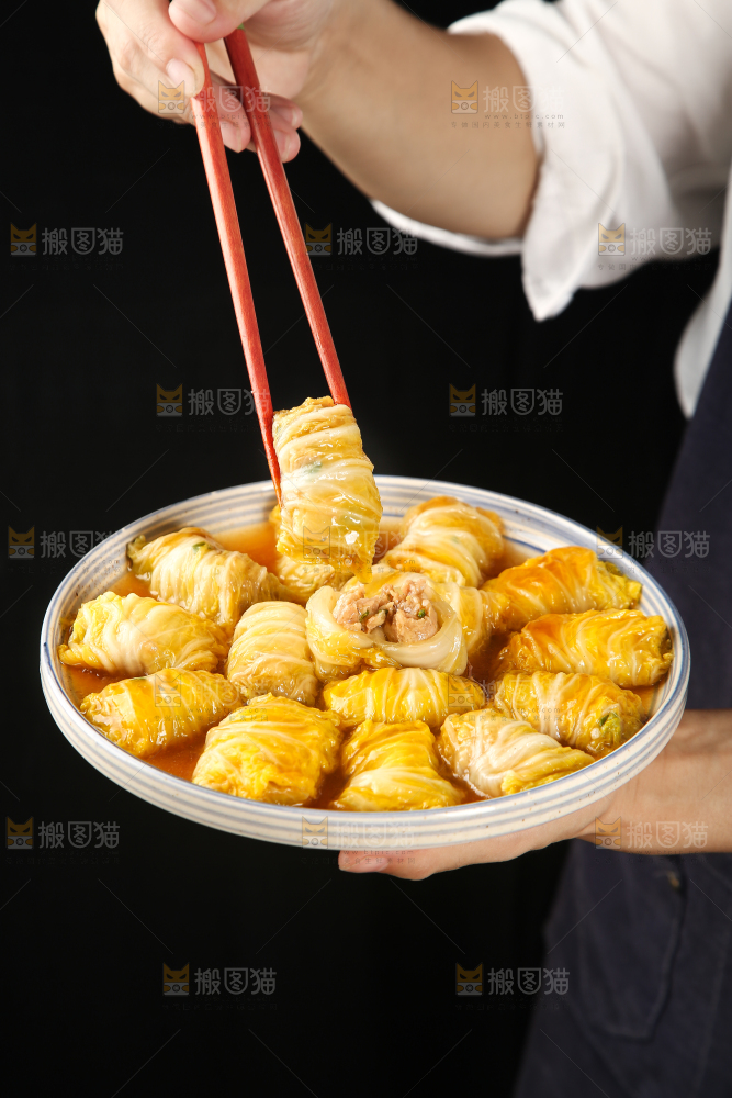 手里端着一盘白菜酿肉卷