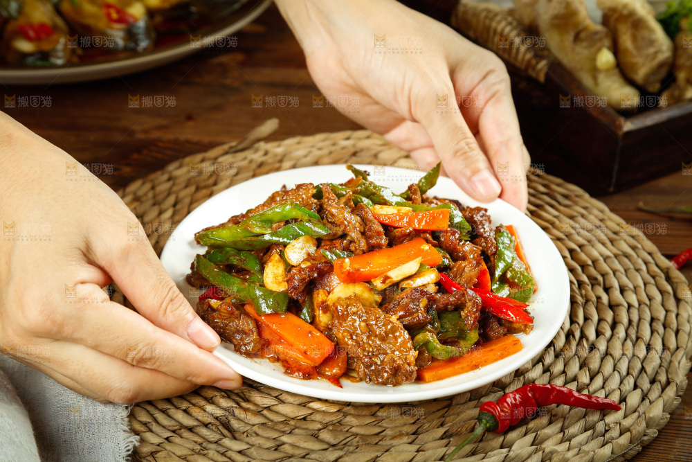 手里端着一盘辣椒炒牛肉