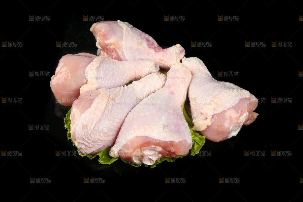 一堆新鲜鸡腿摆放在黑底上