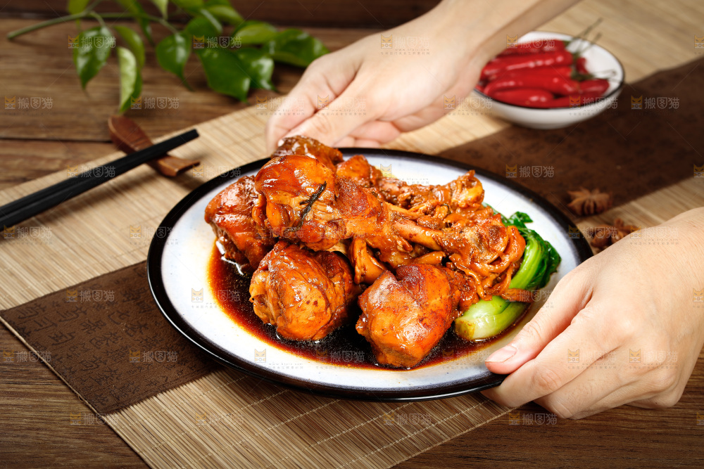手里端着一盘红烧鸡腿