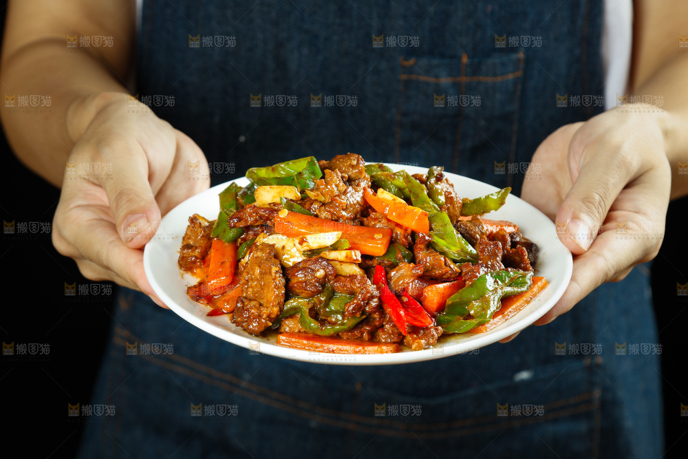 手里端着一盘辣椒炒牛肉