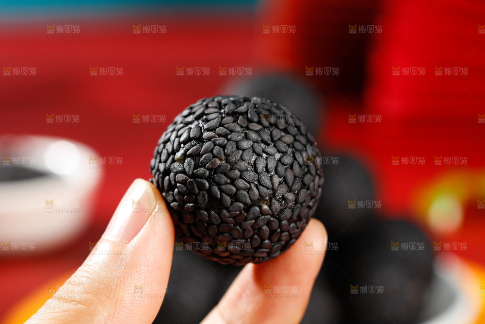 手里拿着芝麻丸子