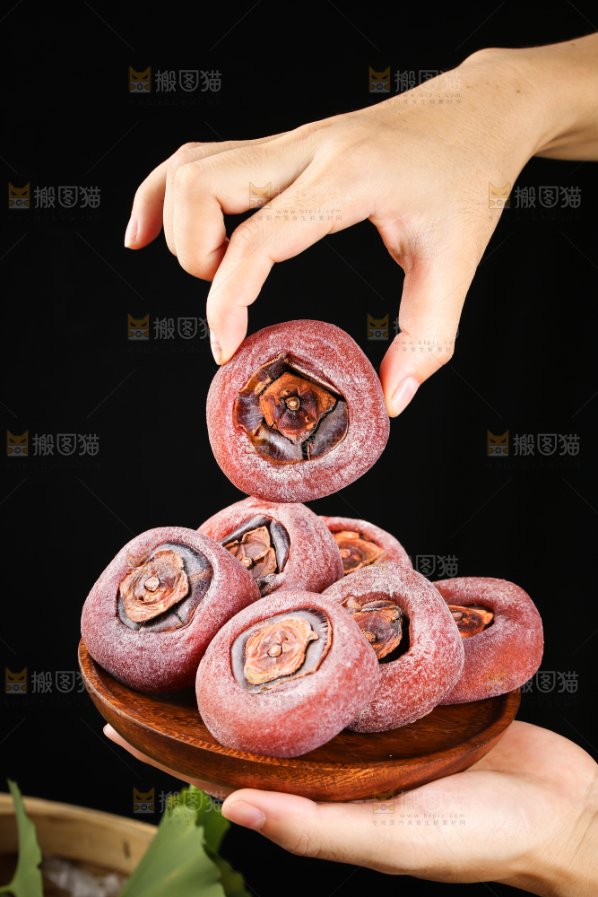 手里端着一盘圆柿饼