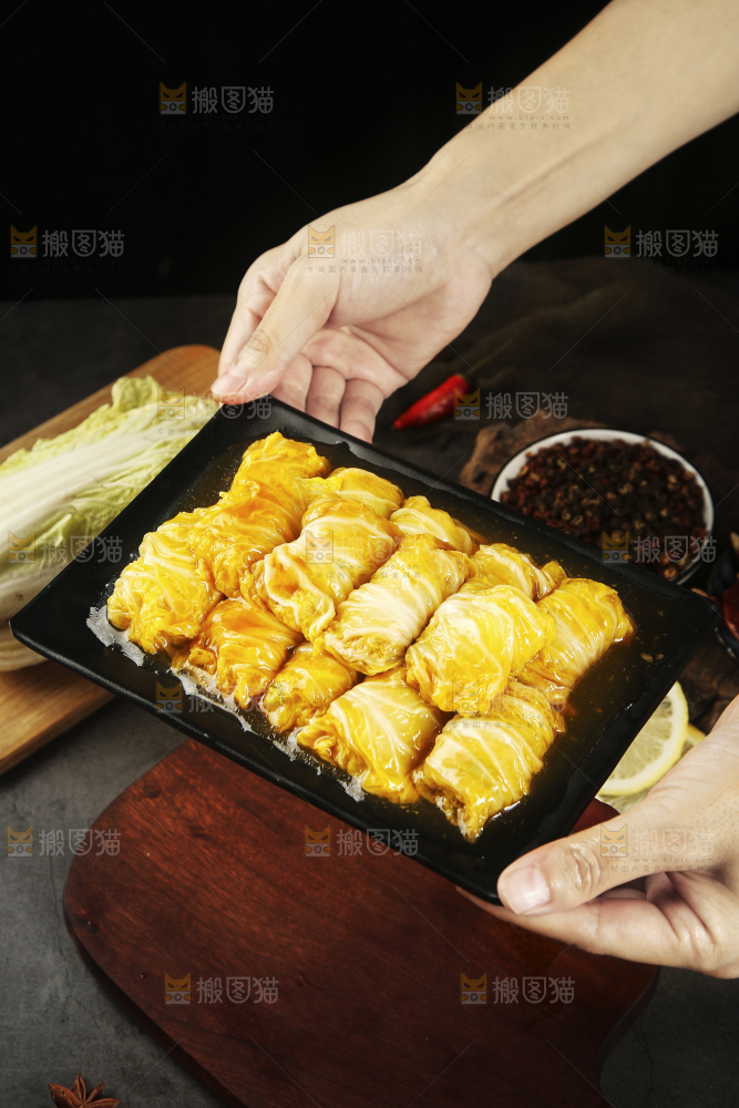 手里端着一盘白菜酿肉卷