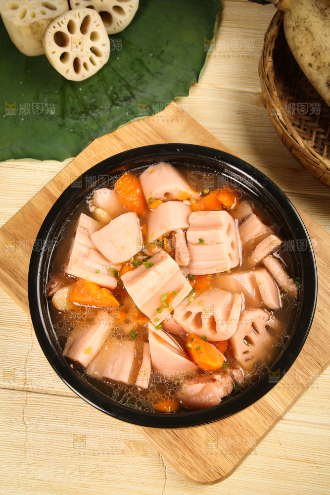 木板上放着一碗胡萝卜莲藕汤