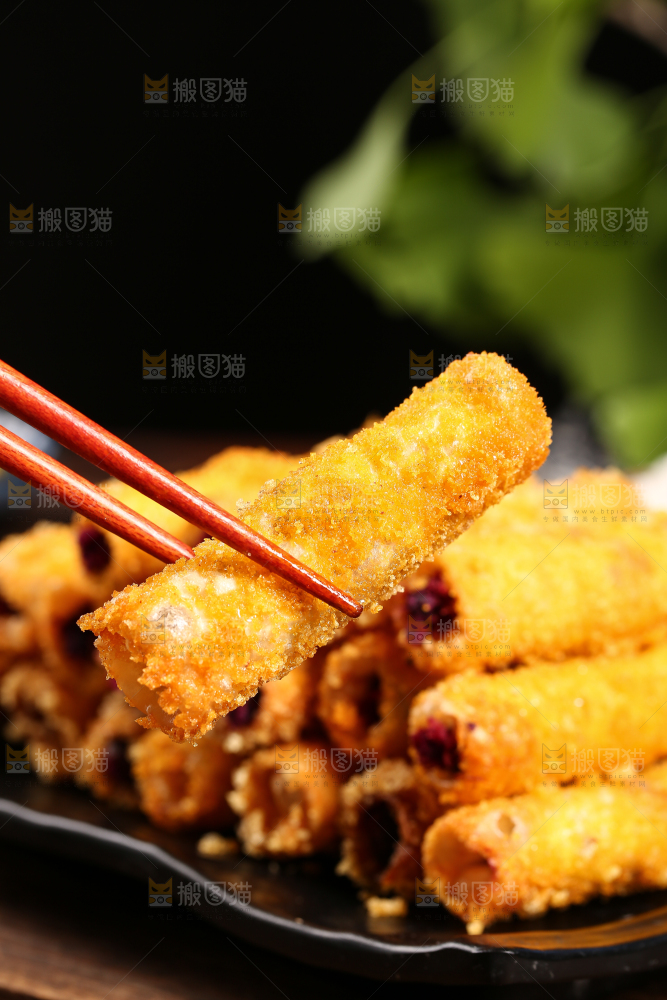 筷子上夹着油炸紫薯卷