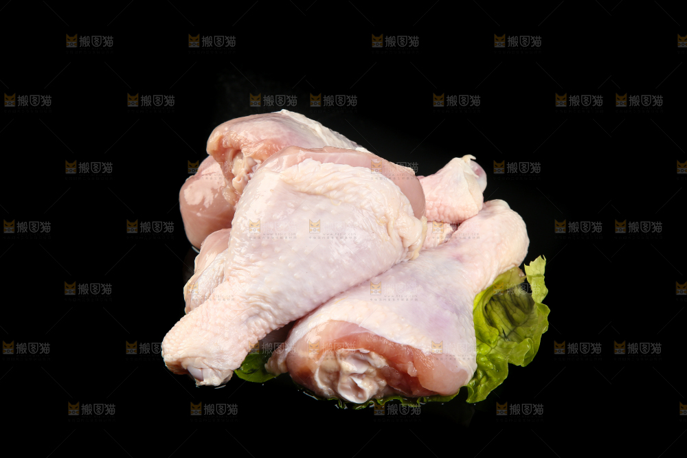一堆新鲜鸡腿摆放在黑底上