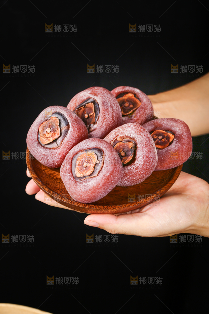 手里端着一盘圆柿饼