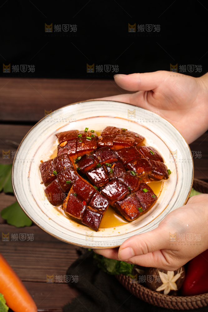 手里端着一盘东坡肉