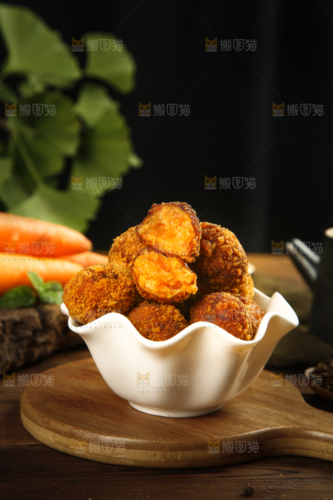 木板上摆放着一碗胡萝卜丸子