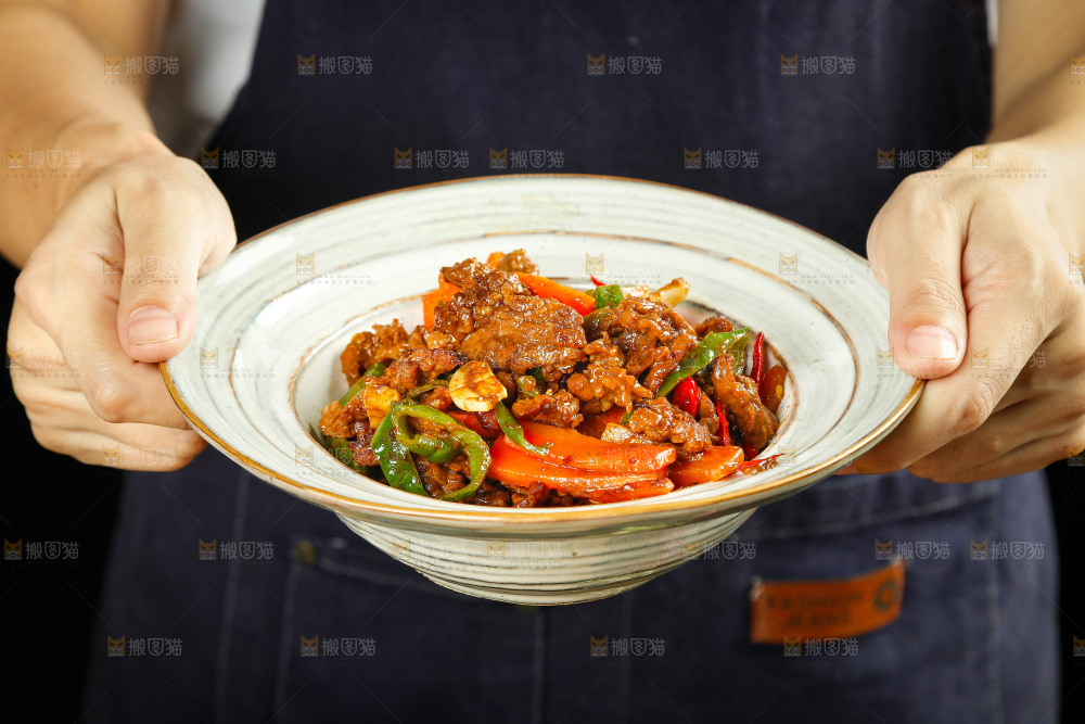 手里端着一盘香辣牛肉