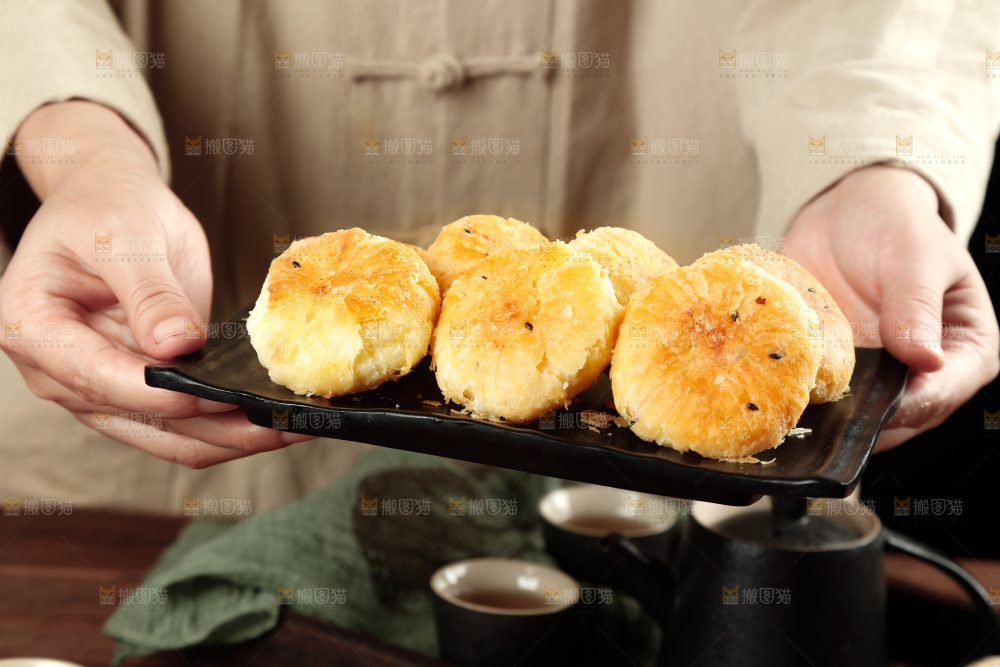 手里端着一盘酥饼