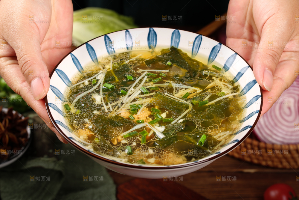 手里端着一盘裙带菜汤