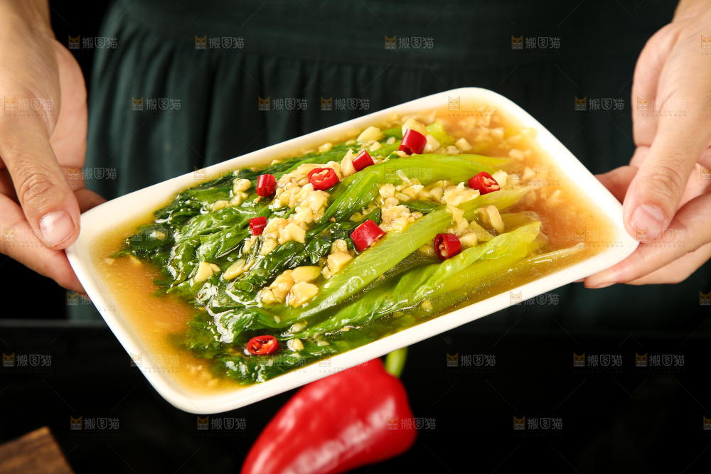 手里端着一盘蒜蓉生菜