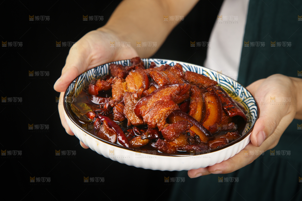 手里端着一盘把子肉