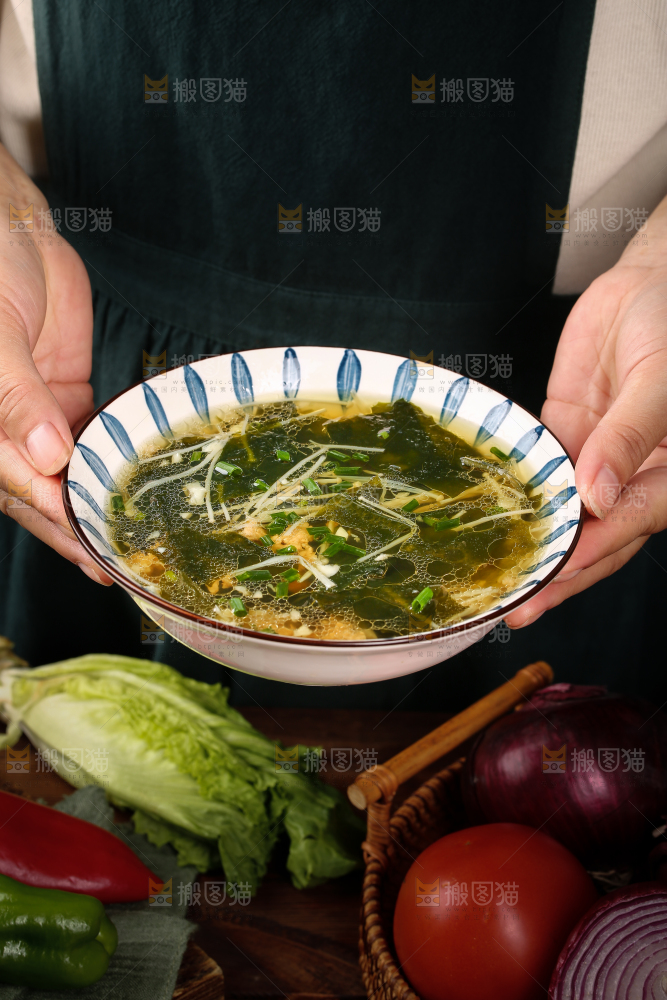 手里端着一盘裙带菜汤