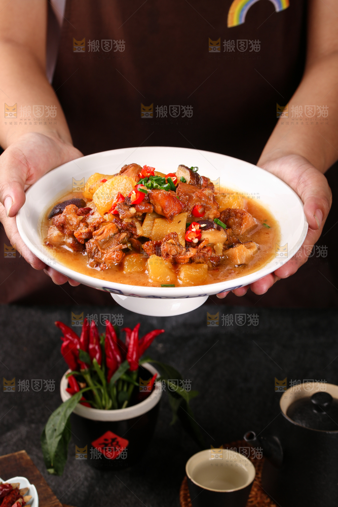 手里端着一盘土豆香菇焖鸡