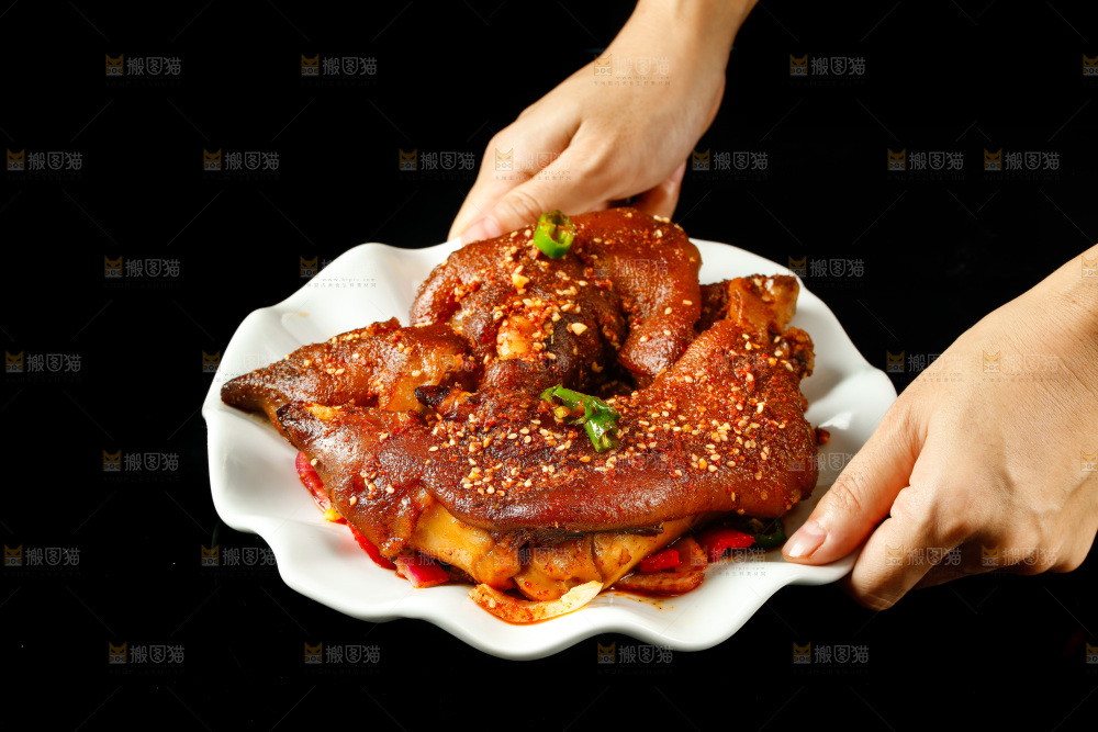 手里端着一盘香酥烤猪蹄