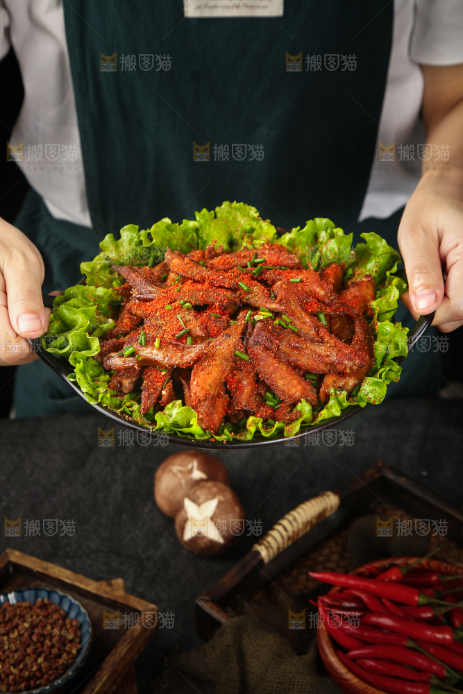 手里端着一盘香辣孜然鸡翅尖