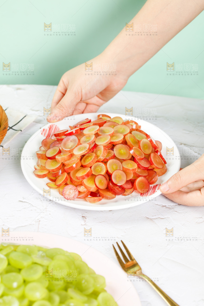 手里端着一盘红提葡萄果肉