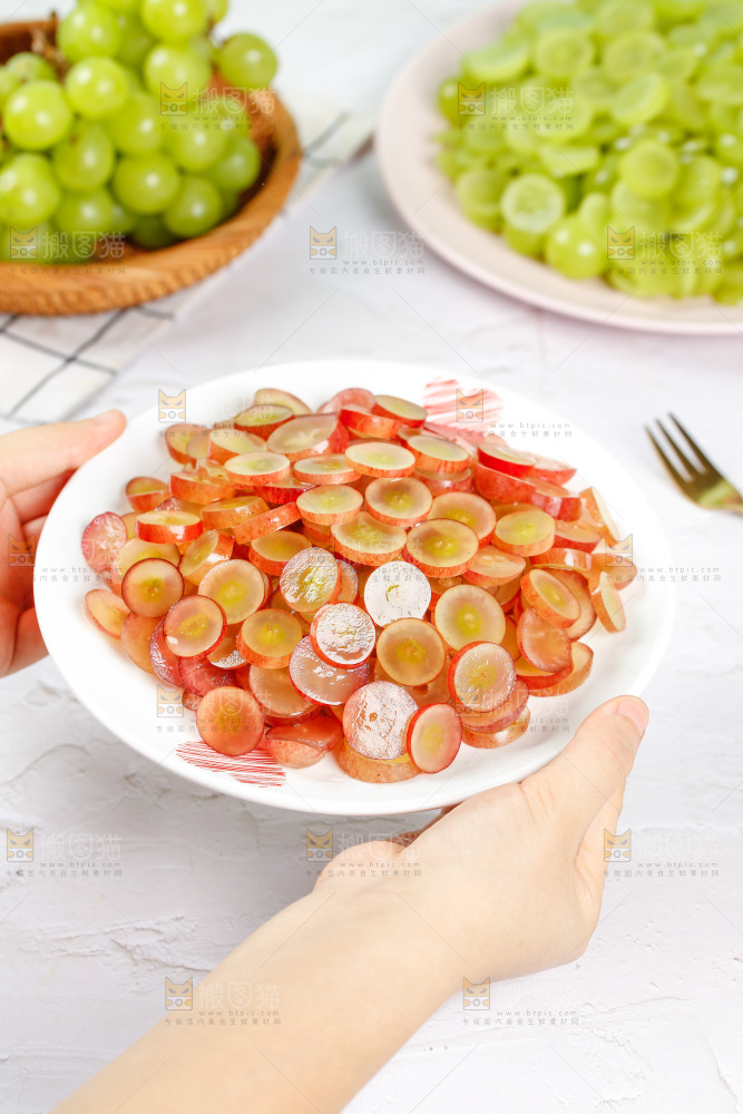 手里端着一盘红提葡萄果肉