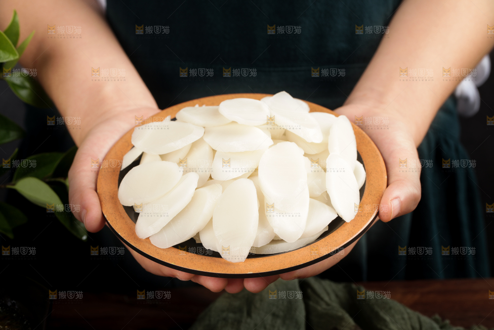 手里端着一盘宁波年糕片