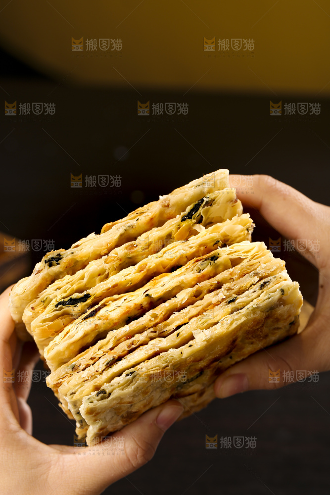 手里拿着梅干菜锅盔