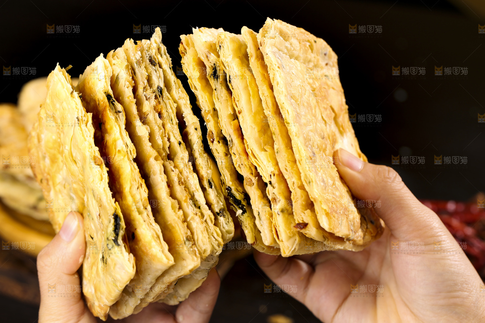 手里拿着梅干菜锅盔