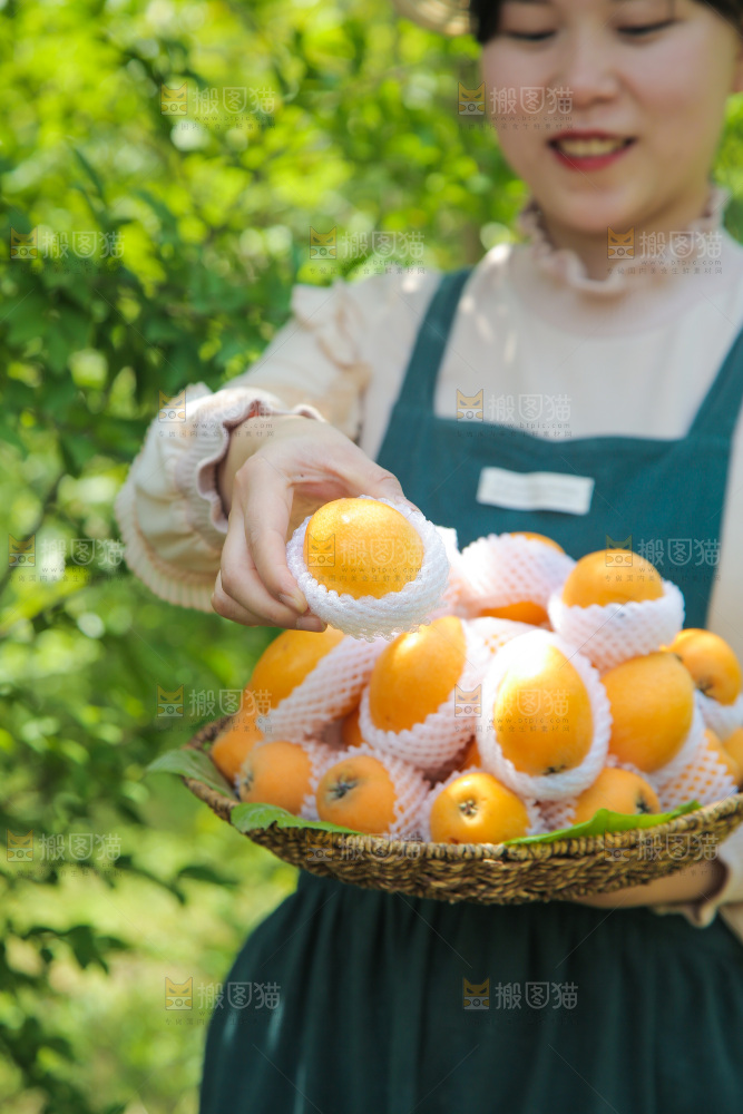 手里端着一篮大枇杷