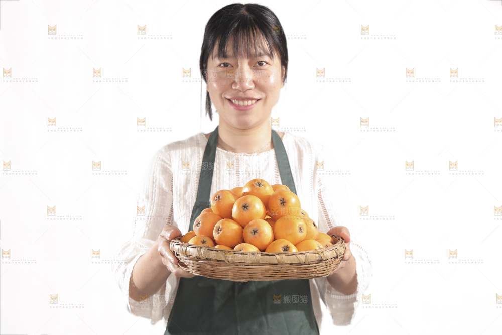 女人手里端着一篮枇杷