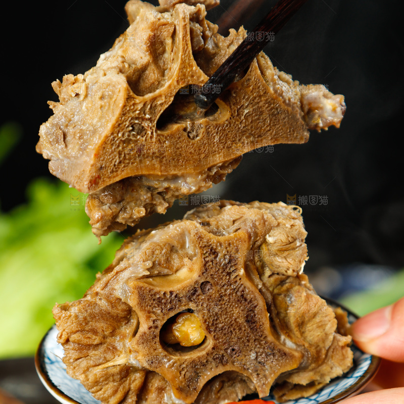 手里拿着煮熟的羊蝎子