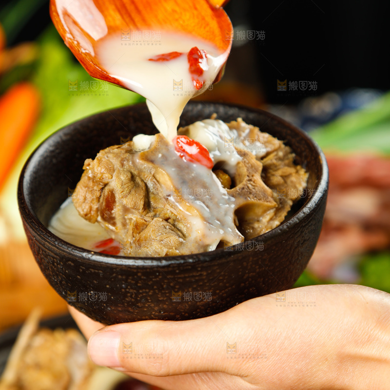 手里端着一碗羊蝎子汤