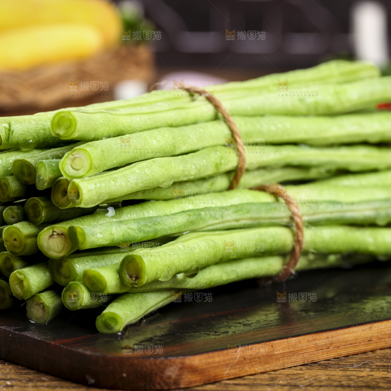 木板上放着一盘新鲜豆角