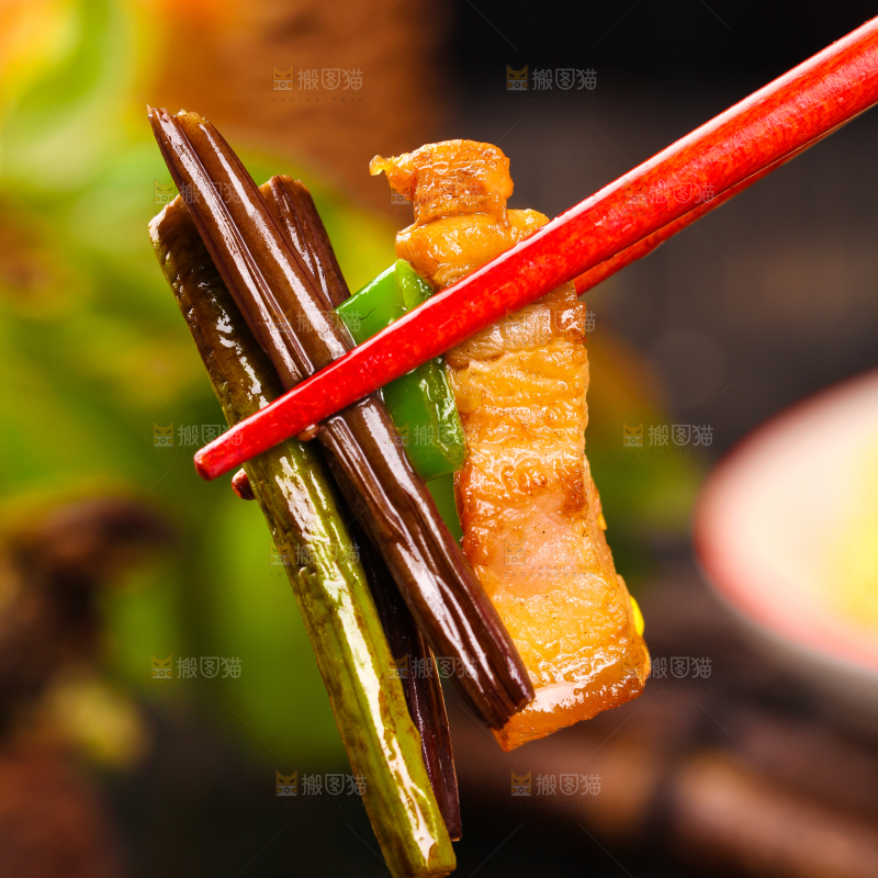 筷子夹着蕨菜炒肉