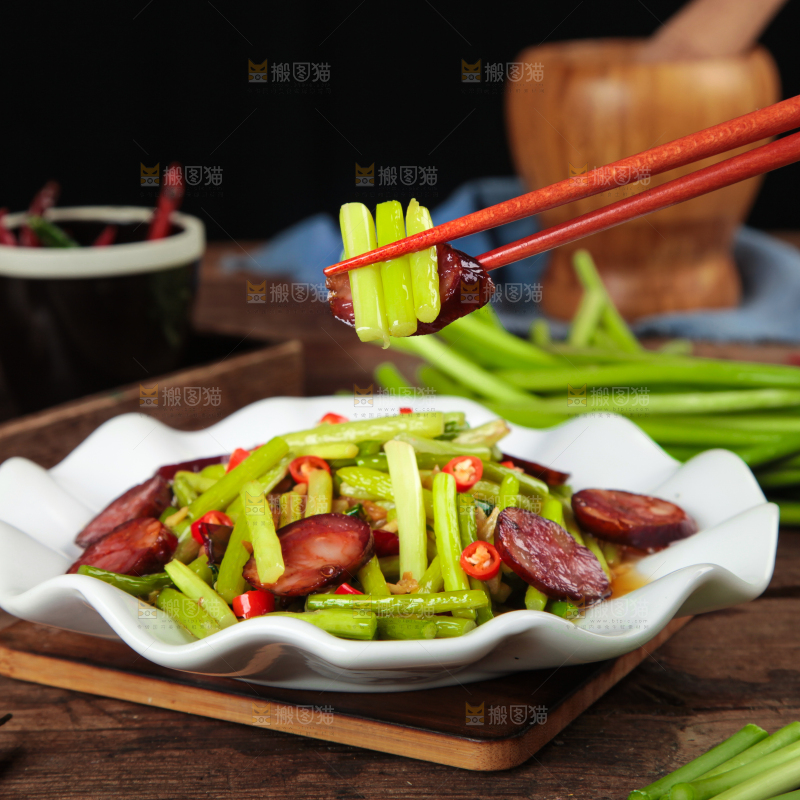 筷子夹着腊肠炒蒜苔