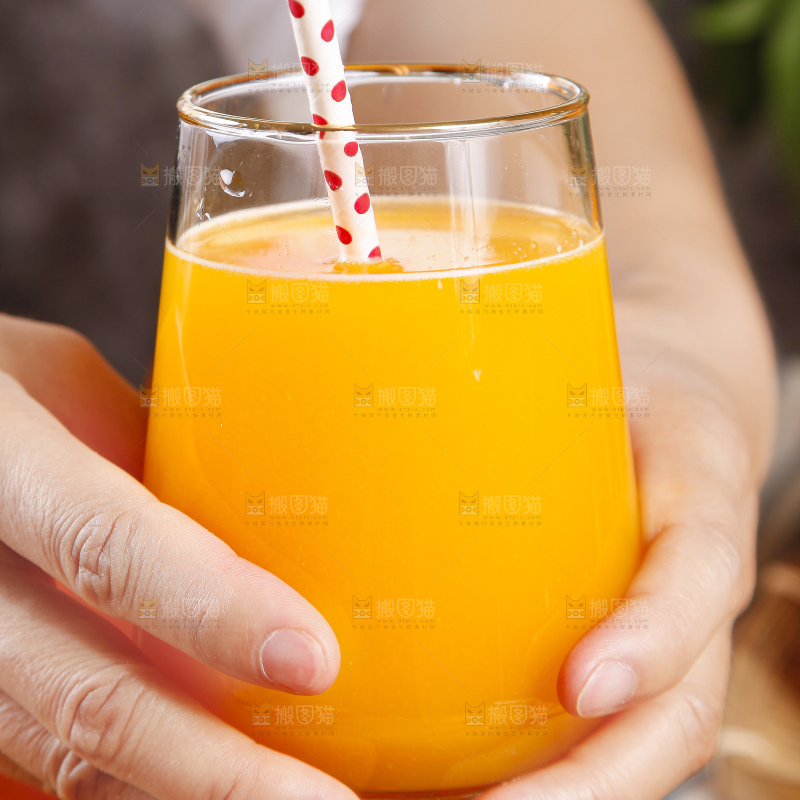 手里拿着一杯橘柑汁