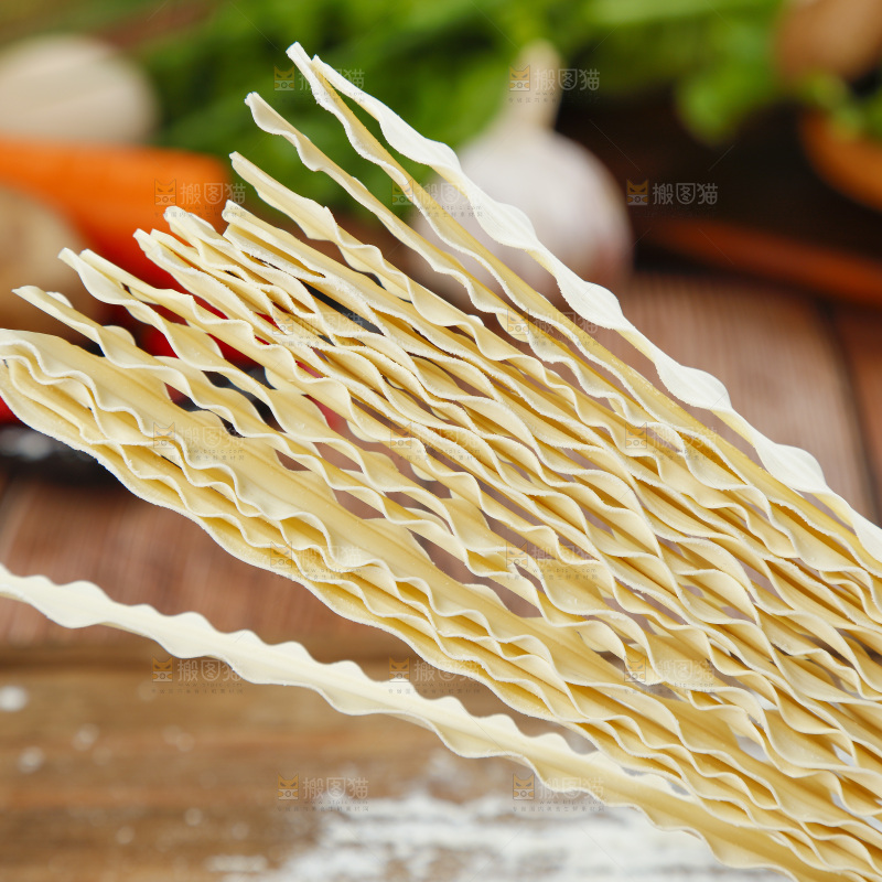 手上拿着手工刀削面