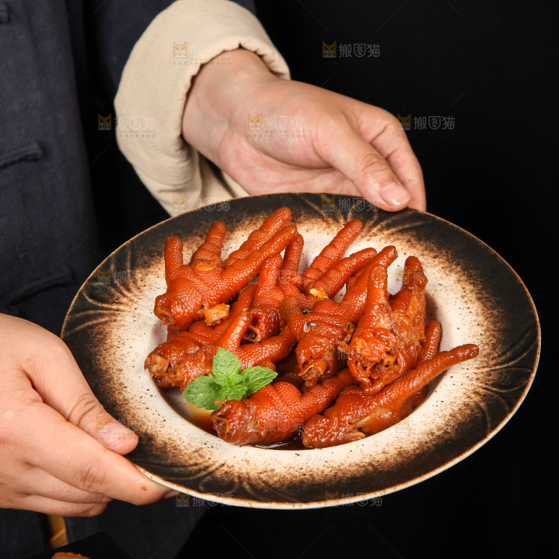 手里拿着一盘卤鸡爪